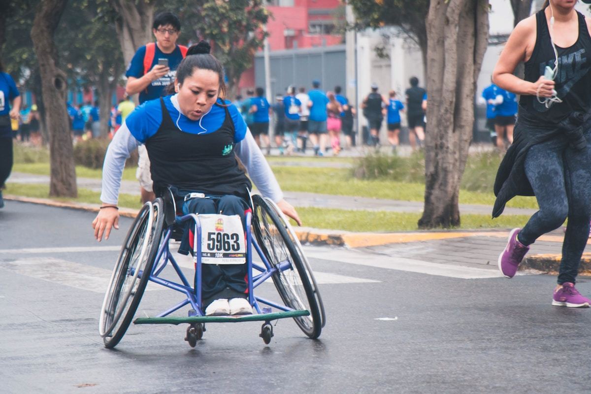 Atleta em cadeira de rodas de corrida participando de uma prova de rua
